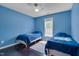 Blue bedroom with ceiling fan, dark wood flooring, and ample natural light at 106 Dairy Ct, Chapel Hill, NC 27516