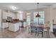 Bright kitchen with white cabinets, island, stainless steel appliances, and an adjacent eating area at 106 Dairy Ct, Chapel Hill, NC 27516