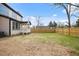 Large backyard with a wood fence, covered patio, and lush green grass at 112 1St St, Oxford, NC 27565