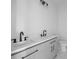 Bright bathroom featuring dual sinks with dark fixtures, gray cabinetry, and vanity lighting at 112 1St St, Oxford, NC 27565