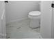 A bright bathroom featuring a toilet and marble tiling on the floor at 112 1St St, Oxford, NC 27565