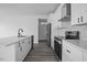 Bright kitchen features white cabinetry, stainless appliances, and a marble backsplash at 112 1St St, Oxford, NC 27565
