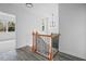 Bright landing with modern light fixture and view to living area, classic banister and wood-look flooring at 112 1St St, Oxford, NC 27565