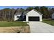 Newly constructed home with a gray exterior, black garage door, and a well-manicured lawn at 120 Magnolia Run Way, Benson, NC 27504
