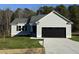 Newly constructed home with a gray exterior, black garage door, and a well-manicured lawn at 120 Magnolia Run Way, Benson, NC 27504