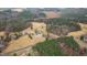 High-angle view of the estate, highlighting the house, pond, and extensive wooded area at 1200 Spring Valley Lake Rd, Henderson, NC 27536