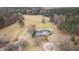 Aerial view of a beautiful two-story white home with a pond surrounded by lush greenery and mature trees at 1200 Spring Valley Lake Rd, Henderson, NC 27536