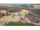 Expansive aerial view of the property, showcasing the home, pond, and surrounding wooded landscape at 1200 Spring Valley Lake Rd, Henderson, NC 27536