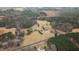 Drone shot of the property, featuring the house, pond, and lush wooded surroundings at 1200 Spring Valley Lake Rd, Henderson, NC 27536