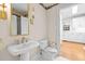 Classic bathroom with decorative wallpaper, gold fixtures, and white pedestal sink at 1200 Spring Valley Lake Rd, Henderson, NC 27536