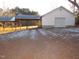 Exterior shot of the garage and covered parking area, set against a backdrop of trees at 1200 Spring Valley Lake Rd, Henderson, NC 27536