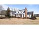 Elegant white two-story house with a brick chimney, manicured shrubs, and a inviting front porch at 1200 Spring Valley Lake Rd, Henderson, NC 27536