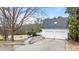 Exterior view featuring a two-car garage, side deck, and a paved driveway leading to the home at 1200 Spring Valley Lake Rd, Henderson, NC 27536