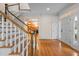 Elegant foyer featuring hardwood floors, a staircase, and a glimpse into a wood-paneled room at 1200 Spring Valley Lake Rd, Henderson, NC 27536