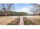 Brick path with manicured bushes leading up to a circular driveway, creating a welcoming approach to the property at 1200 Spring Valley Lake Rd, Henderson, NC 27536