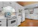 Bright kitchen with white cabinets, wood ceiling, brick accent wall, and stainless steel appliances at 1200 Spring Valley Lake Rd, Henderson, NC 27536