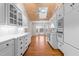 Open kitchen featuring wood ceiling, white cabinets, and views to the dining area with a large window at 1200 Spring Valley Lake Rd, Henderson, NC 27536