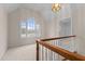 View of carpeted landing with attractive light fixture and large arched window overlooking property at 1200 Spring Valley Lake Rd, Henderson, NC 27536