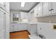 Functional laundry room with sink, white cabinetry and washer dryer hookups at 1200 Spring Valley Lake Rd, Henderson, NC 27536