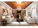 Elegant living room featuring rich wood trim, a fireplace, built-in bookshelves, and a coffered wood ceiling at 1200 Spring Valley Lake Rd, Henderson, NC 27536