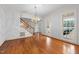 Bright living room with hardwood floors, a staircase, and large windows, providing natural light at 1200 Spring Valley Lake Rd, Henderson, NC 27536