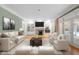 Bright living room with a fireplace, built-in shelving, light hardwood floors, and French doors to a backyard at 1200 Spring Valley Lake Rd, Henderson, NC 27536