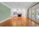 Spacious living room featuring hardwood floors, a brick fireplace, and access to an outdoor space at 1200 Spring Valley Lake Rd, Henderson, NC 27536