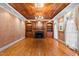 Bright living room showcasing wood-paneled ceiling, hardwood floors, and a cozy fireplace at 1200 Spring Valley Lake Rd, Henderson, NC 27536