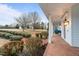 Inviting porch with brick flooring, white columns, outdoor lighting, and a view of the expansive yard at 1200 Spring Valley Lake Rd, Henderson, NC 27536