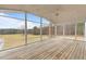 Screened porch with wooden floors and view of large green grass yard at 1200 Spring Valley Lake Rd, Henderson, NC 27536