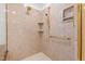 Luxurious shower with gold fixtures, built in shelves and tan marble walls at 1200 Spring Valley Lake Rd, Henderson, NC 27536