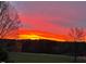 Beautiful sunset view over a lush green lawn, enhancing the property's scenic appeal at 1200 Spring Valley Lake Rd, Henderson, NC 27536