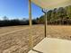 Covered patio overlooking a large backyard with mature trees at 125 Hydrangea Ln, Benson, NC 27504