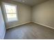 Well-lit bedroom with carpet flooring and large window at 125 Hydrangea Ln, Benson, NC 27504