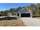 Newly constructed home with green vinyl siding and a black garage door at 125 Hydrangea Ln, Benson, NC 27504