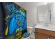 A bathroom with a fun, colorful gaming themed shower curtain and matching toilet seat cover, offering a unique design at 128 S Clearbrook Ct, Angier, NC 27501