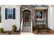 Inviting entryway with stone steps, a solid wood door, and charming architectural details at 128 S Clearbrook Ct, Angier, NC 27501