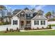 Charming two-story home featuring a stone facade, manicured lawn, and inviting front porch at 128 S Clearbrook Ct, Angier, NC 27501