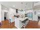 Modern kitchen with white cabinets, quartz countertops, island with seating, and hardwood floors at 128 S Clearbrook Ct, Angier, NC 27501
