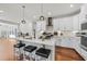 Bright kitchen with a marble island, three stools, and modern stainless steel appliances at 128 S Clearbrook Ct, Angier, NC 27501
