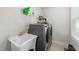 Bright laundry room with a sink and a modern washer and dryer, as well as a shelf for your detergent at 128 S Clearbrook Ct, Angier, NC 27501