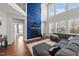 Sunlit living room features a floor-to-ceiling fireplace, hardwood floors, and a gray sectional couch at 128 S Clearbrook Ct, Angier, NC 27501