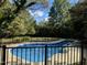 Inviting kidney-shaped pool surrounded by a black fence at 1307 Shamrock Dr, Burlington, NC 27215