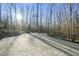 Spacious stone patio with fireplace, seating area, and wooded backdrop at 148 Hidden Creek Ct, Pittsboro, NC 27312
