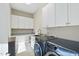 Functional laundry room with washer, dryer, cabinets and a utility sink at 148 Hidden Creek Ct, Pittsboro, NC 27312