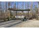 Relaxing patio with pergola, seating, fire pit, and wooded view at 148 Hidden Creek Ct, Pittsboro, NC 27312