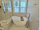 Bright bathroom features a standalone tub, decorative glass windows, and modern finishes for a spa-like experience at 1709 Chestnut Falls Rd, Wendell, NC 27591