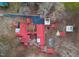 Overhead view of home with a red metal roof, outbuildings, landscaping, driveway, and surrounding bare trees at 253 Ronald Tharrington Rd, Louisburg, NC 27549