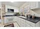 Corner kitchen with white cabinets, dark countertops and a window at 253 Ronald Tharrington Rd, Louisburg, NC 27549