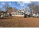 Beige home with a red metal roof, a brick base, and an adjacent gazebo and deck on a sunny day at 253 Ronald Tharrington Rd, Louisburg, NC 27549